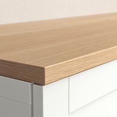 a close up view of the top of a white and oak dresser with drawers on each side