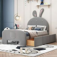 a child's bedroom with a bed, dresser and toy rabbit head on the wall