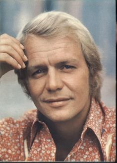 an old photo of a man with blonde hair and blue eyes wearing a floral shirt