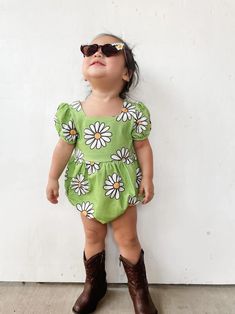 The green daisy romper is the perfect vintage-inspired piece for your little girl. Featuring a cool daisy print on a cheery green background, a square neckline, and cute puff sleeves, your little one will be irresistibly cute in this nostalgic romper. Not only will they look absolutely cute in this timeless piece, they will be so comfortable since it's made from a stretchy cotton spandex blend material. What's better than sweet vintage style with modern comfort for a little one? Cute Short Sleeve Bubble Romper For Spring, Spring Cute Short Sleeve Bubble Romper, Cute Green Bubble Romper For Playtime, Cute Summer Floral Print Bubble Romper, Playful Floral Print Bubble Romper For Spring, Spring Playful Floral Print Bubble Romper, Floral Print Fitted Cotton Bubble Romper, Playful Fitted Short Sleeve Jumpsuits And Rompers, Playful Fitted Short Sleeve Jumpsuit