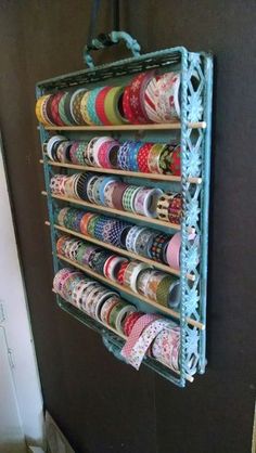 a rack with many different colored tapes hanging on it's sides and the bottom shelf is made out of metal