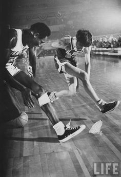 a black and white photo of two boys playing basketball