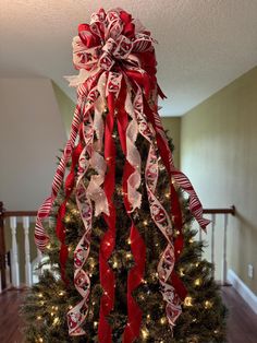 a decorated christmas tree with red and white ribbons