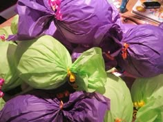 purple and green flowers sitting on top of a table