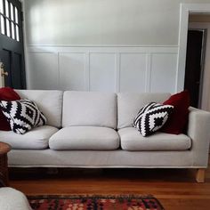 a white couch with red and black pillows