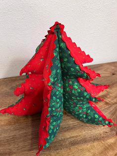 three red and green christmas trees sitting on top of a wooden table