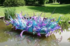 a boat that is sitting in the water with purple and blue decorations on it's side