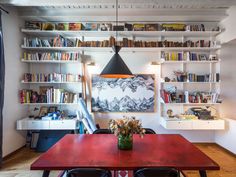 a dining room table with chairs and bookshelves in the background