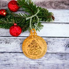 a christmas ornament hanging from a tree branch with ornaments around it on a wooden table