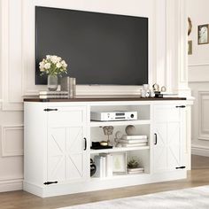 a flat screen tv mounted to the side of a white entertainment center with sliding doors