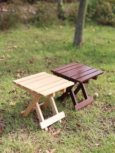 two wooden picnic tables sitting in the grass