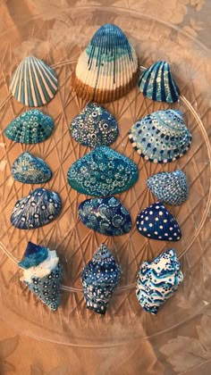 several seashells are arranged in a circle on a glass platter with blue and white designs