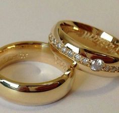 two gold wedding rings with diamonds on them