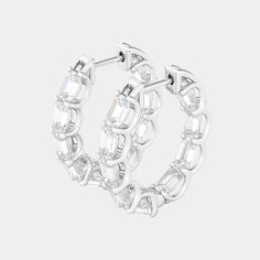 a pair of white gold hoop earrings with clear stones on the inside, set in 18k white gold