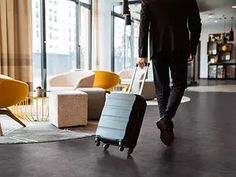 a man is walking with his luggage in the hotel lobby while looking out the window