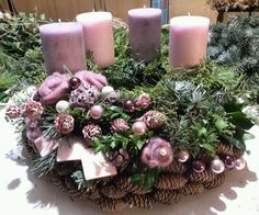 a table topped with candles and flowers next to pine cones