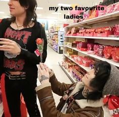 two women in a store talking to each other while one holds her hand out for the other