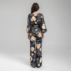 Experience effortless style and comfort with our Balance Kimono Top. This viscose blend kimono features an asymmetrical design and a v-neckline. The beautiful floral print adds a touch of femininity to the pinstriped fabric. This kimono top features an inset adjustable belt at backwaist to quickly alter it to your silhouette. Dress it up with heels or dress it down with trainers for a versatile look. 40% CO 40% VI 15% PE 5% EA  Fine wash at 30 degrees Iron at middle heat Do not tumble dry Bohemian V-neck Sets For Spring, Spring Printed Viscose Sets, Floral Print V-neck Kimono For Brunch, V-neck Floral Print Kimono For Brunch, Casual V-neck Kimono For Brunch, Spring V-neck Beachwear Kimono, Chic V-neck Kimono For Summer, Elegant V-neck Kimono For Spring, Elegant Beach Sets For Spring