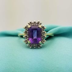 STUNNING Vintage 14K Yellow Gold Amethyst Diamond Halo Ring-Beautifully Crafted. Made in the 1990s.  Amethyst is the Birthstone for the Month of February. This Ring Would Make a Wonderful Birthday Gift! This Lovely, and Eye-Catching Ring features an Emerald Cut, Royal Purple Amethyst Gemstone that is Surrounded by Dazzling Bright White Diamonds. The Ring Itself is Made from Solid and Stamped 14K Yellow Gold. The Emerald cut amethyst measures 7.5mm in Length x 5.7mm Wide = 1.25CT The Diamonds mea 14k Yellow Gold Amethyst Ring With Halo Setting, Formal Purple Birthstone Ring With Halo Setting, Formal Purple Halo Birthstone Ring, Gold Amethyst Ring With Emerald Cut, Birthstone, 14k Gold Emerald-cut Amethyst Ring With Center Stone, Gold Emerald Cut Amethyst Birthstone Ring, Fine Jewelry 14k Gold Amethyst Ring With Halo Setting, Amethyst Anniversary Ring With 17 Jewels, Gold Amethyst Ring With Diamond Halo Setting