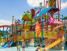 children playing in the water at an outdoor play area with slides and splash waterslides