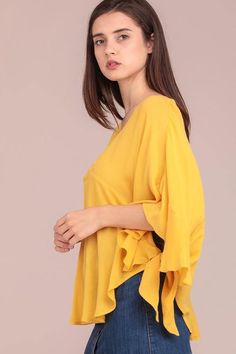 Ruffle poncho sleeves Poncho top with side tie and V-neck Materials: 100% Cotton Color: Yellow Model is 5'8" and wearing a Small Spring Chic Poncho With Batwing Sleeves, Chic Spring Poncho With Batwing Sleeves, Flowy Poncho With Batwing Sleeves, V-neck Tops With Tie Sleeves For Brunch, V-neck Top With Tie Sleeves For Brunch, Spring Bell Sleeve Tops With Tie Sleeves, Yellow Bohemian One Size Poncho, Yellow V-neck Tunic For Beach, Oversized V-neck Poncho For Spring