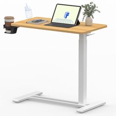 a laptop computer sitting on top of a wooden desk next to a cup of coffee