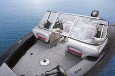 the inside of a motor boat with seats and steering wheel on the water's edge