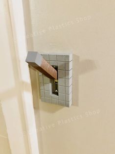 the corner of a room with a tile wall and wooden door handle on it's side