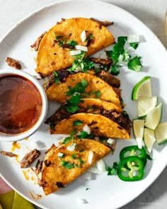 a white plate topped with tacos and sauce