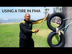 a man holding onto two tires on the side of a pole with text over it that reads using a tire in fma