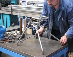 a man working on a metal object in a shop