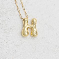 Bubbling with personality, this initial pendant infuses your everyday jewelry lineup with a bold and personalized accessory that creates your individuality! When we found these bubble letter charms we knew we needed to design our own version. Handmade in house at E&O with a tiny gold paperclip chain and lobster clasp. Of course we knew we had to offer this gem in 2 lengths for personal preference!! Features: Gold plated paperclip chain in 16' and 19" lengths 24K gold plated bubble letter charm L Bubble Letter Necklace, Gold Bubbles, Bubble Letter, Bubble Letters, Letter Charm, Stone Collection, Letter Charms, Charm Set, Initial Pendant