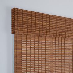 a close up of a bamboo blind on a wall with white walls in the background