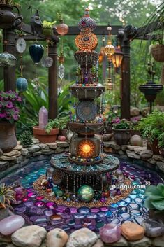 an outdoor fountain surrounded by plants and rocks