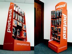 an orange display case filled with lots of cell phones on top of each other in front of a white wall