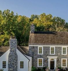 a large stone house with white trim and windows