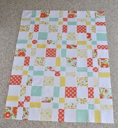 a patchwork quilt is laying on the floor with it's edges cut off