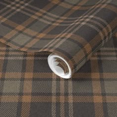 a brown and black checkered fabric with a white circle on the end of it