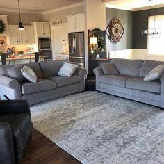 a living room with two couches and a rug on the floor in front of it