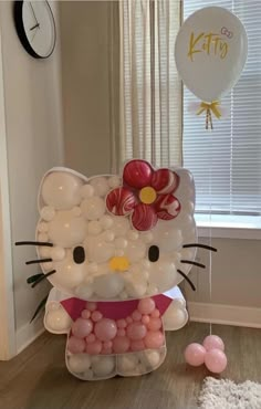 a hello kitty balloon and some balloons in a room