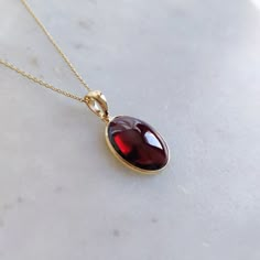 ITEM DESCRIPTION: >> The Pendant is made from Solid 14K Yellow Gold. Gemstone used is absolutely natural and ethically sourced. >> Natural Garnet in cabochon cut and oval shape with bezel setting is studded on it with utmost precision.  >> This is a minimalist design and is absolutely hassle-free and everyday jewelry.  Gem: Garnet Gem size: 12x14 mm oval Gem weight: 6.33 carats Gold purity: 14K (58.33% approx.) Gold weight: 0.49 grams  Gross weight: 1.76 grams The Gold purity is guaranteed and it comes with authentic 14K gold hallmark. Since this Pendant are handmade, It is Nickel/Lead FREE.  CUSTOMIZATION: --> Earrings of the same design can be made. --> You can choose your own gemstone. --> Kindly drop a message for the same. CUSTOMER SUPPORT: --> We are available 24/7 to respond to all Garnet Pendant Necklace, Exquisite Yellow Gold Gemstones For Gifts, Yellow Gold Garnet Necklaces With Oval Shape, Yellow Gold Oval Garnet Necklace, Elegant Oval Garnet Necklace, Oval Garnet Necklaces For Anniversary, Oval Garnet Necklace For Anniversary, Elegant Polished Gemstones For Gift, Elegant Oval Gemstones For Gifts