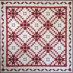 a red and white quilt with stars on it