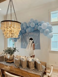 a bride and groom standing in front of a table with bags on it, surrounded by balloons