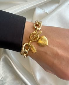 "Introducing an exquisite accessory: the Gold Heart Bracelet. Meticulously crafted with durable aluminium chains and captivating metal charms, this one-of-a-kind creation is tailored for the modern woman. Featuring a bold and chunky chain, it elegantly fastens with a unique round charm and a fingerprinted gold heart charm. Delicately adorned with a \"love\" bar, this exclusive piece can only be found at Christina Christi. 👉 My Women Bracelets Collection: https://etsy.me/2U57si7 👉 Express Shipping: https://etsy.me/3ikUnOM MATERIALS - Aluminium Chains. - Metal Charms. DIMENSIONS - The bracelet, has length 16.5 cm (6,38'') (Adjustable) - If you would like to have more or less cm to your bracelets, you can inform me with a message before your order. PROTECTION - Protect it from water, parfum Luxury Chain Bracelet With Heart Charm As Gift, Cheap Chain Charm Bracelet For Women, Luxury Elegant Charm Bracelet For Women, Affordable Everyday Charm Bracelet With Chain, Cheap Everyday Chain Charm Bracelet, Gold Chunky Chain Bracelet, Affordable Heart-shaped Charm Bracelet, Luxury Bracelets With Heart Charm, Luxury Heart Charm Bracelet For Women