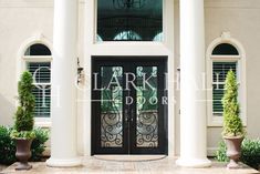 the front entrance to a large house with columns and glass doors that lead into it