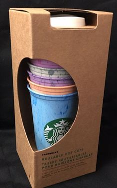 four starbucks coffee cups in a cardboard box