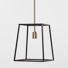 a black and gold hanging light fixture on a white wall with an open square frame