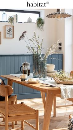 a dining room table with plates, cups and vases sitting on top of it