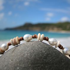 Superb organic bracelet featuring small Australian cultured white pearls between 10,5 and 9,5 mm strung on leather with little white tumbled beach stones. My leather is totally hand-worked using traditional sailors knots techniques. Designed to last, this bracelet will develop a superb patina over time. Please choose in the option menu if you prefer your fine cultured pearls WHITE AUSTRALIAN or BLACK OF TAHITI. (Photo model: Australian white). Pearl shape Half-baroque / circle Length ON REQUEST Bohemian White Pearl Bracelet For Beach, White Pearl Bracelet With Charm For Beach, Adjustable Hand-strung Pearl Bracelet For Beach, White Bracelets With Pearl Charm For Beach, White Natural Stones Bracelets For Beach, White Natural Stones Bracelets For The Beach, White Bohemian Bracelet With Pearl Charm, Bohemian White Bracelets With Pearl Charm, Bohemian White Bracelet With Pearl Charm