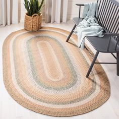 the rug is on the floor next to a chair and potted plant in front of a window